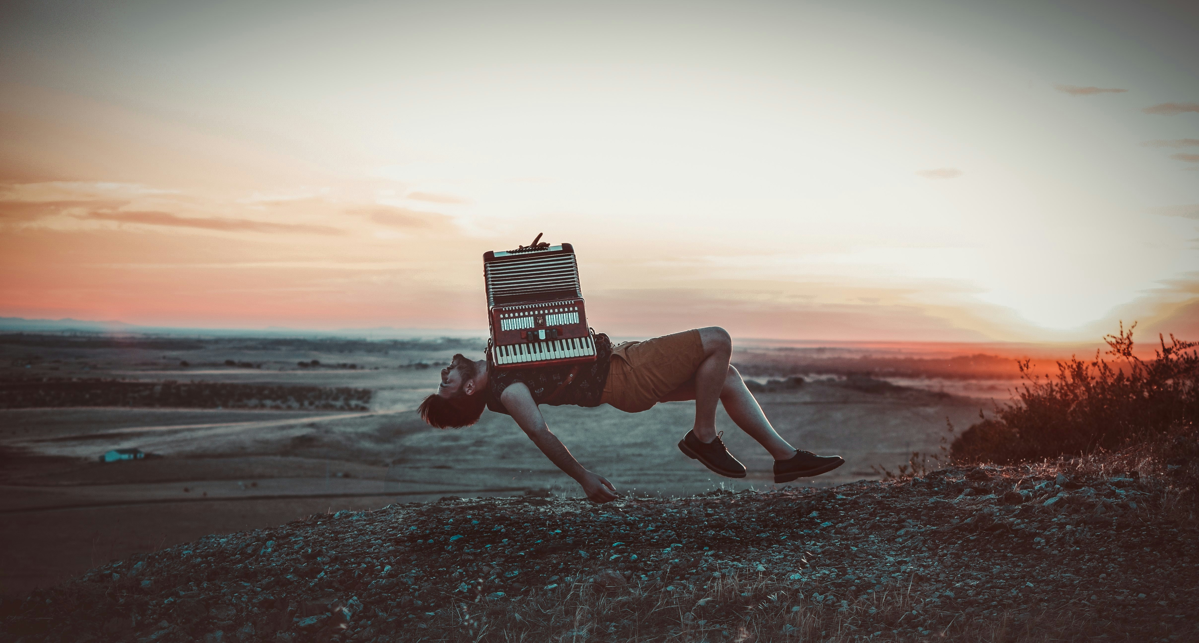 Person rising above the landscape at sunset